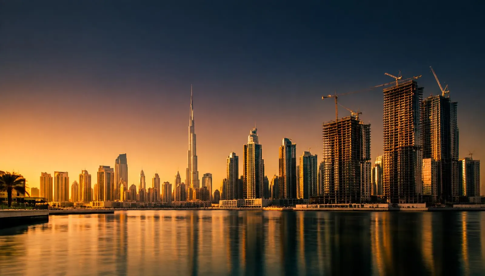 Skyline de Dubaï au coucher du soleil avec des tours résidentielles en construction au bord de la crique